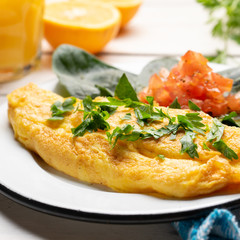 French omelette with tomato and spinach on white background