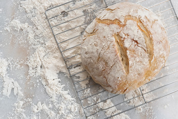 Rustic White Bread cooling on a baking rack on a marble pastry board