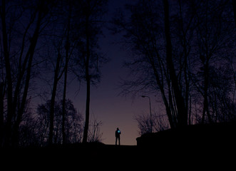 man in the forest with a flashlight in his hands