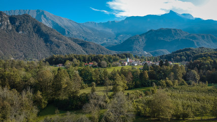 Fototapeta na wymiar Valley of Kobarid in early morning with Svino village in the foreground. Beautiful green autumn panorama of villages along Soca river in Slovenia