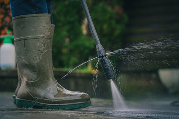 Person cleaning a rug or floor mat with the use of a high pressure water cleaner. Cleaning mats...