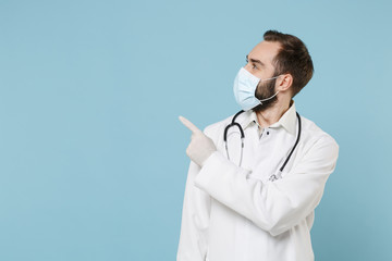 Male doctor man in white medical gown sterile face mask gloves isolated on blue background....