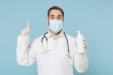 Doctor man in medical gown face mask gloves isolated on blue background. Epidemic pandemic...