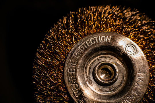 A close-up of power drill metalic golden brush on black background