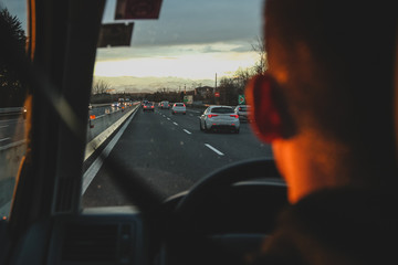 Man driving a car on a motorway with some traffic,