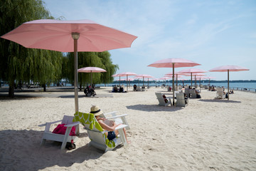 People sun bathing on the beach with umbrella
