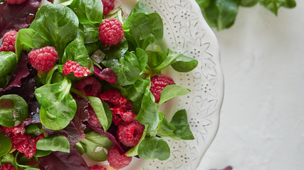 Fragrant aromatic raspberry and spinach in white plate with colorful sauce