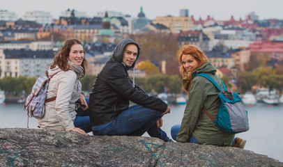 Group of tourists is posing on the Skinnarviksberget lookout viewpoint, way above the Stockholm....
