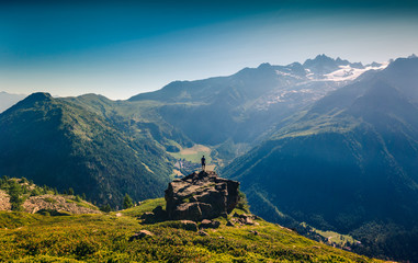 Rear view of man looking at view while standing on rock