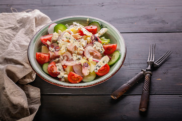Close up seafood salad with octopus, cucumber, radish, blue cheese and cherry tomatoes.