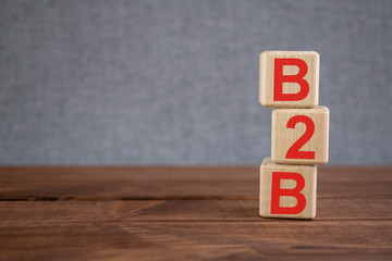 B2B (business to business) acronym on wooden cubes on dark wooden backround. Business concept.