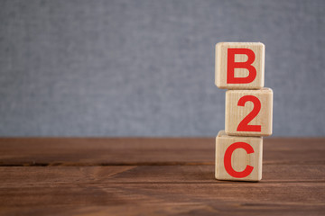 B2B (business to consumer) acronym on wooden cubes on dark wooden backround. Business concept.