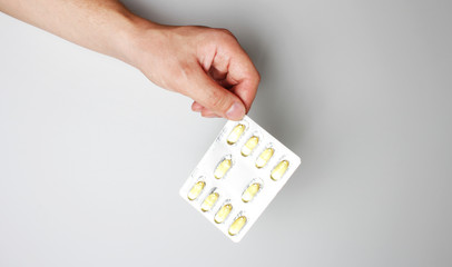 blister capsule in hand on a light background