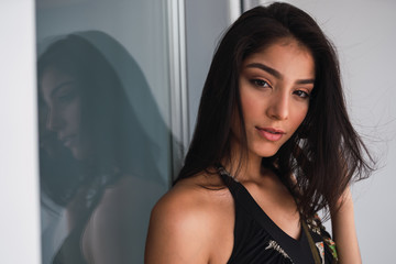 Beautiful passionate brunette Hispanic woman in black wear looking at the camera