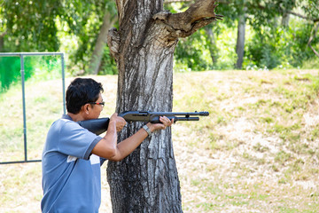 asian man hold gun shooting shotgun sport training on filed