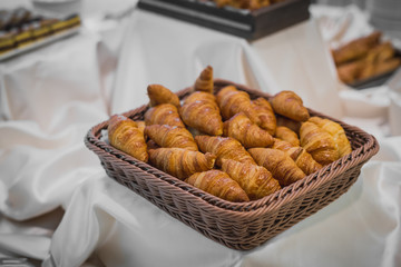 Fresh croissants in a basket on display at a gala event or at a banquet.
