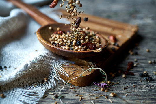 Dry mix of spices and dried berries in spoon on table