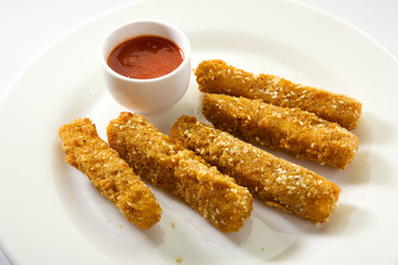 Crispy fried mozzarella sticks served with spicy marinara dipping sauce. Appetizing Fried Mozzarella Sticks isolated on white background