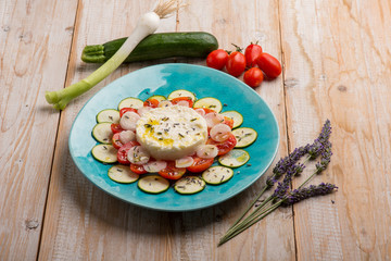 mozzarella cream with sliced zucchinis tomatoes and lavender flower