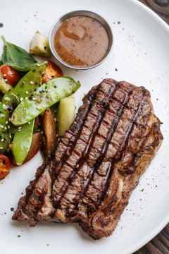 From Above Top View Of Grilled Beef Steak With Basil And Vegetable Serving On Plate With BBQ Sauce