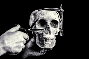 Barber scissors and straight razor, barber shop. Still life skull with shaving tools. Barber shop tool on black background with copy space. Skull barber. Black and white