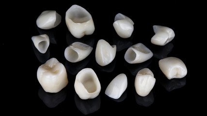set of dental crowns made of ceramic for total prosthetics of the patient on a black background