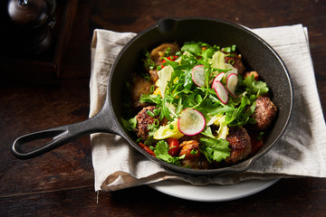 From above fried cutlets with fresh green herbs tomatoes slices of radish in metal pan 