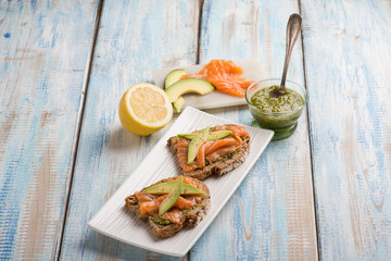 sliced bread with pesto sauce smocked salmon and avocado
