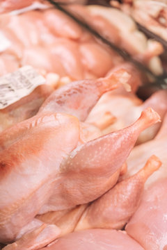 From above heap of uncooked chicken meat placed inside refrigerator in grocery store