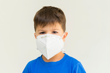 Closeup of caucasian boy wearing surgical mask. Face mask for protection against coronavirus outbreaks. Concept of protection against biological threat. Social isolation to prevent respiratory disease