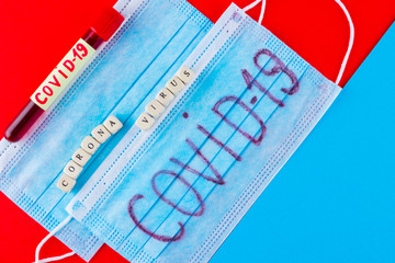 Coronavirus - COVID-19. Test tube with blood identified by the COVID-19 on blue red background....