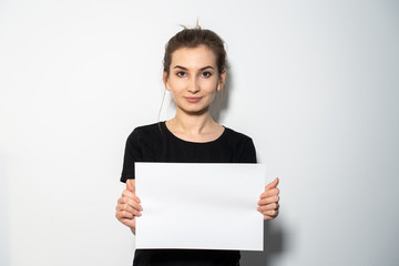 Girl holding a white paper in hands