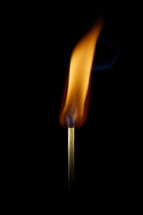 A burning match on a black background