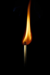 A burning match on a black background