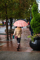 young woman walking with umbrella in the rain