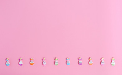 Decorative easter clothespins for decor on a pink background, copy space, flat lay