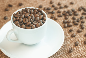 Cup of coffee beans. Coffee beans scattered around