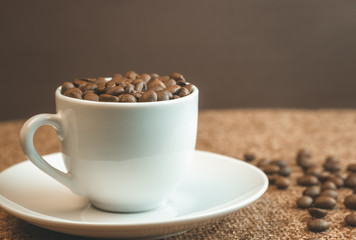 Cup of coffee beans. Coffee beans scattered around