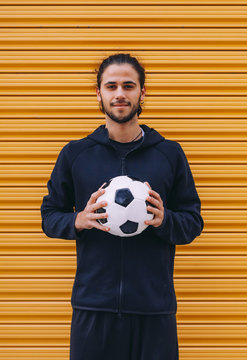 Man playing soccer ball on street