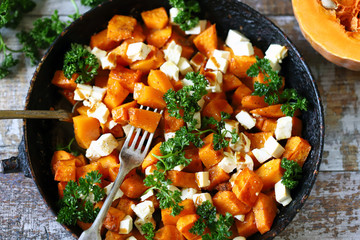 Baked slices of pumpkin with slices of white cheese. Warm salad with pumpkin and feta cheese....