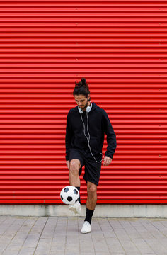 Man playing soccer ball on street
