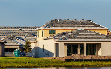 Obraz premium New homes under construction with stacks of tiles on the roof waiting to be installed