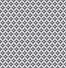 Seamless pattern in the form of a delicate white lace on a black background. Lace with geometric...