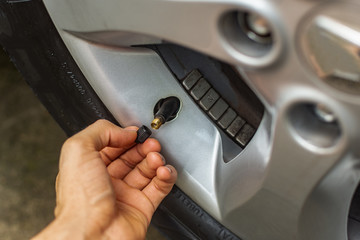 Topic of problems with the car. hand placing tire valve cap on c