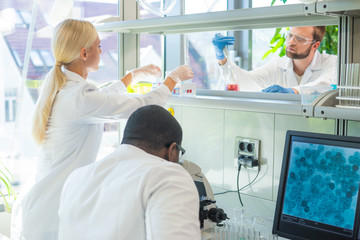 Obraz premium Scientist working in lab. Doctors making medical research. Laboratory tools: microscope, test tubes, equipment. Coronavirus, chemistry, science, experiments and healthcare concept.