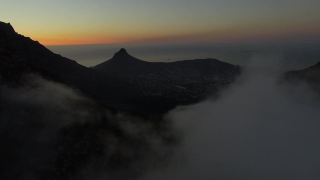 Aerial drone shot revealing Cape Town and Lions Head trough a big cloud