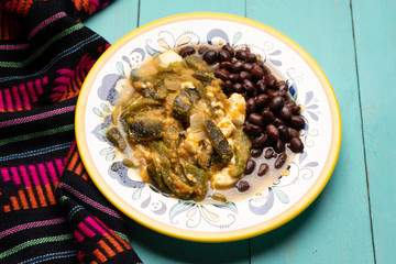 Mexican poblano pepper rajas and panela cheese on turquoise background