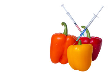 Genetically modified vegetables. GMO food concept. Syringes are stuck in vegetables with chemical additives. Injections into fruits and vegetables. Isolated on white background.