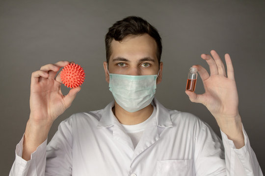 A medical worker holds a model of the coronavirus.