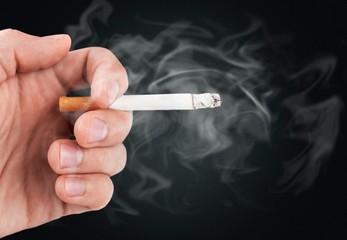 Human hand hold a smoking cigarette
